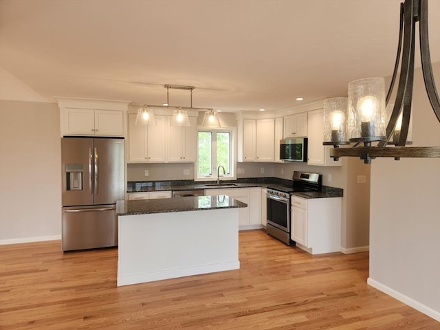 56 Kelly Ln, Lynn, MA 01904 - kitchen with appliances with stainless steel finishes, a sink, white cabinetry, light wood finished floors, and a kitchen island