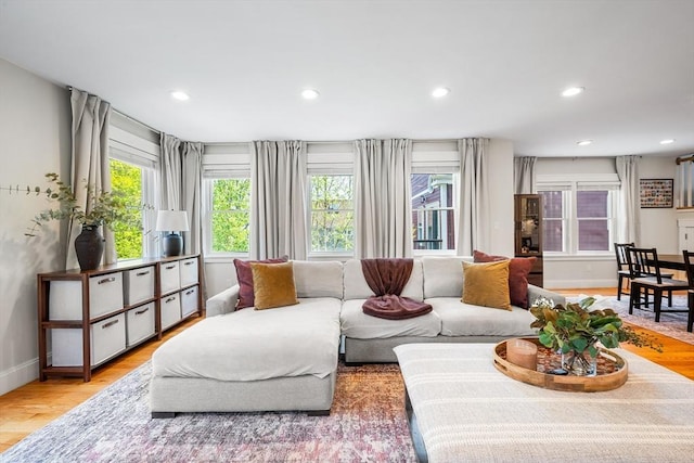 living room with recessed lighting, light wood-style flooring, and baseboards