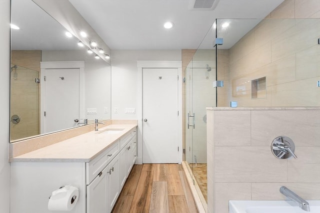 bathroom featuring vanity, recessed lighting, a shower stall, wood finished floors, and visible vents