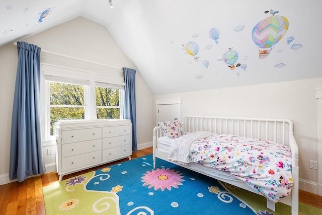 bedroom with wood finished floors, baseboards, and lofted ceiling