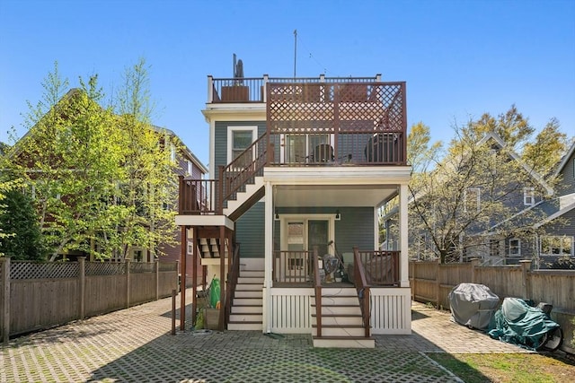 rear view of house featuring stairway, a patio, fence private yard, and a balcony