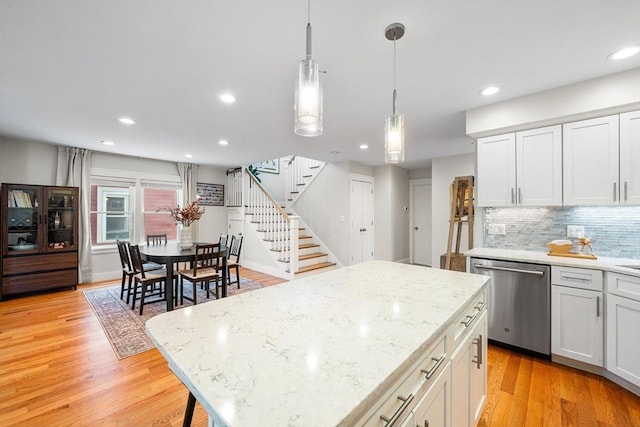 kitchen featuring decorative backsplash, a kitchen island, light wood-type flooring, recessed lighting, and dishwasher