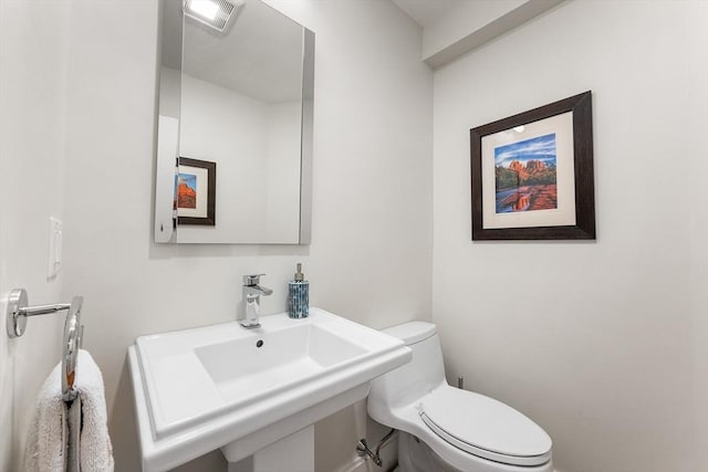 bathroom with visible vents, a sink, and toilet