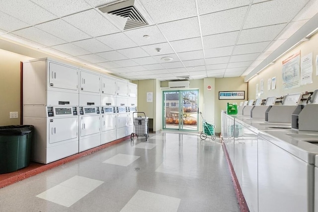 laundry room featuring washer and dryer, an AC wall unit, and stacked washer and clothes dryer