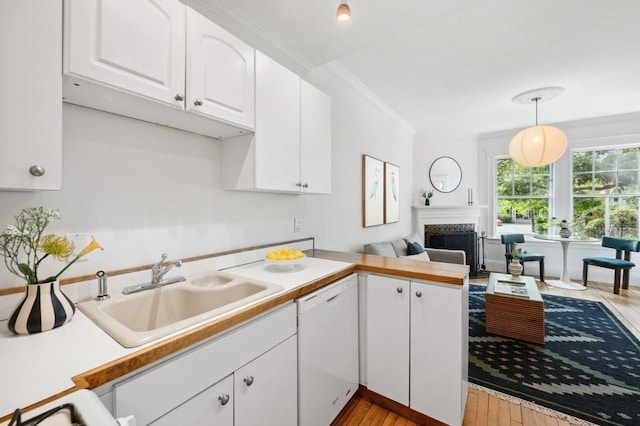 7 Linnaean St Unit 1, Cambridge, MA 02138 - kitchen with dishwasher, a sink, white cabinets, and light wood finished floors
