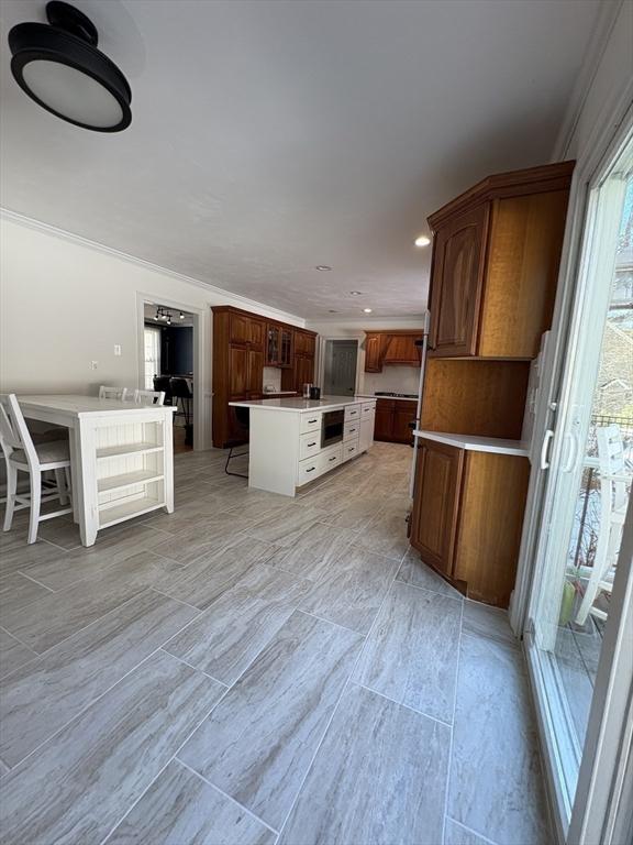 kitchen with a center island, light countertops, recessed lighting, and ornamental molding
