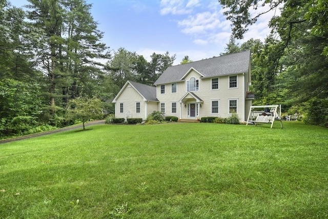colonial-style house featuring a front lawn