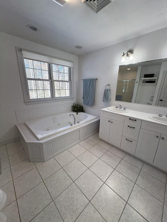 bathroom featuring a stall shower, tile patterned floors, double vanity, and a sink