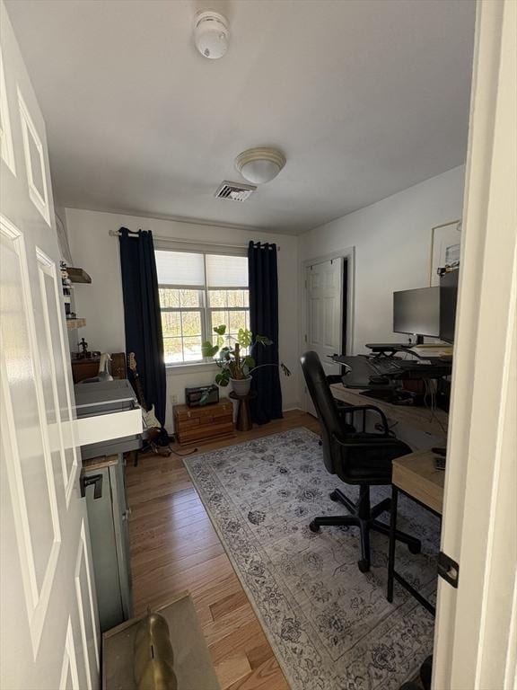 home office with light wood finished floors and visible vents