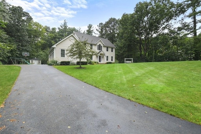 colonial inspired home featuring a front lawn and aphalt driveway