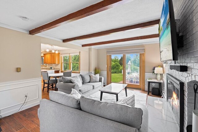 20 Highwood Way, North Andover, MA 01845 - living area with beamed ceiling, a fireplace, light wood-style flooring, a wainscoted wall, and ornamental molding
