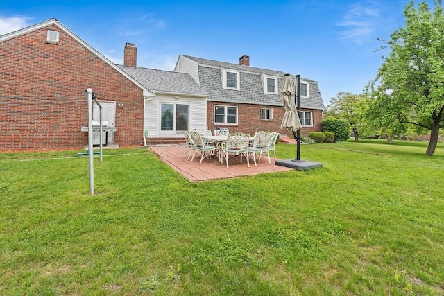 20 Highwood Way, North Andover, MA 01845 - back of property with brick siding, a chimney, a lawn, and a patio area