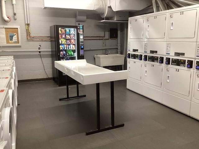 566 Commonwealth Ave # 101, Boston, MA 02215 - kitchen with stacked washing machine and dryer, white cabinetry, washer and clothes dryer, and concrete block wall