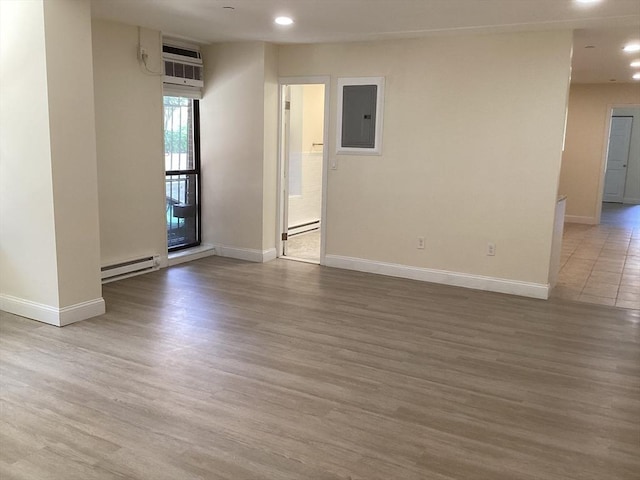 566 Commonwealth Ave # 101, Boston, MA 02215 - spare room featuring electric panel, baseboard heating, an AC wall unit, recessed lighting, and wood finished floors