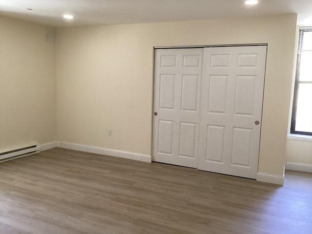 566 Commonwealth Ave # 101, Boston, MA 02215 - unfurnished bedroom with wood finished floors, recessed lighting, a baseboard radiator, and a closet