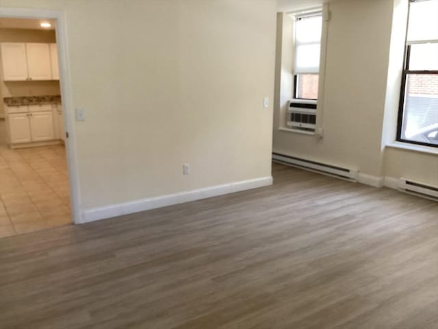 566 Commonwealth Ave # 101, Boston, MA 02215 - spare room with a baseboard radiator, healthy amount of natural light, and light wood-type flooring