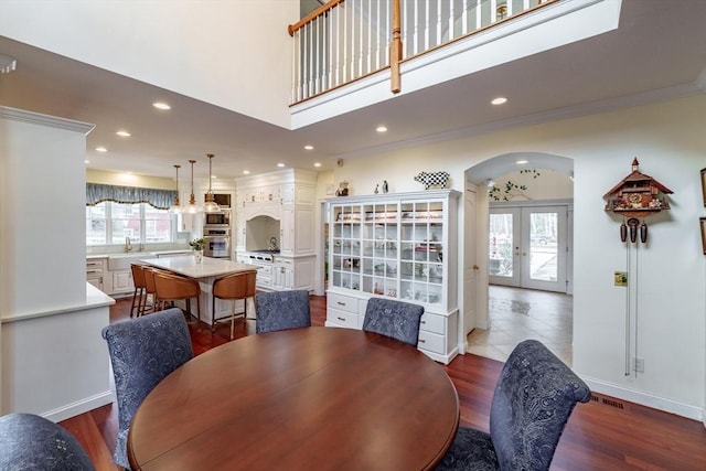 dining room with crown molding, dark wood-type flooring, and french doors