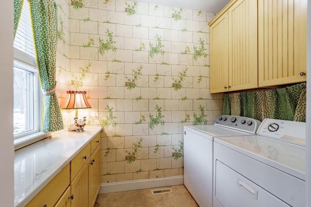 laundry room featuring light tile patterned flooring, cabinets, and washer and dryer