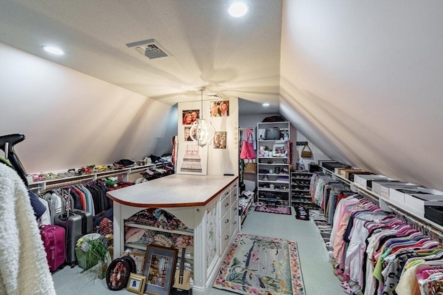 spacious closet with lofted ceiling and light colored carpet