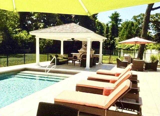 view of swimming pool featuring a gazebo, a patio area, and an outdoor living space with a fireplace