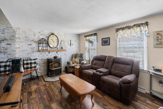 living room with a textured ceiling, baseboard heating, wood finished floors, and a wood stove