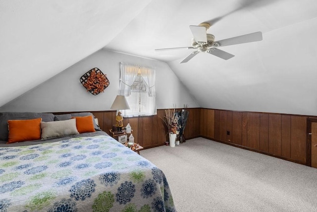 bedroom with light carpet, wooden walls, a wainscoted wall, ceiling fan, and vaulted ceiling