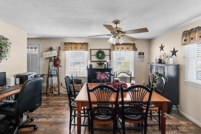 dining space featuring a ceiling fan, dark wood-style flooring, a fireplace, and a textured ceiling