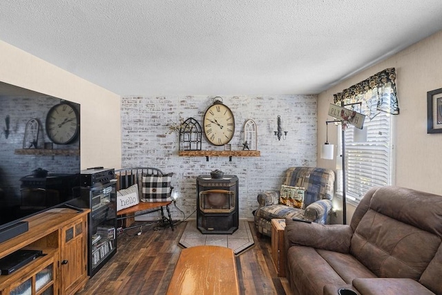 living area with a wood stove, dark wood finished floors, and a textured ceiling