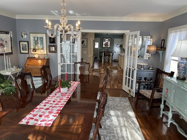 dining room with french doors, dark hardwood / wood-style flooring, crown molding, and a notable chandelier