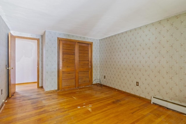 121 Donlyn Dr, Chicopee, MA 01013 - unfurnished bedroom featuring baseboard heating, wallpapered walls, light wood-type flooring, and a closet