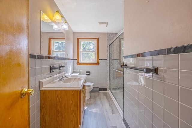 121 Donlyn Dr, Chicopee, MA 01013 - bathroom with tile walls, a stall shower, vanity, a wainscoted wall, and wood finished floors