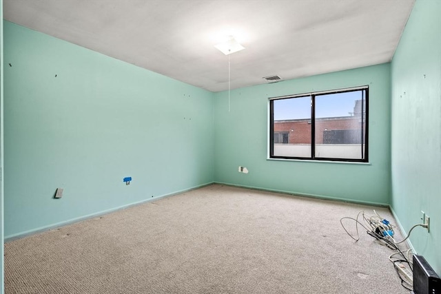 spare room featuring visible vents, carpet floors, and baseboards