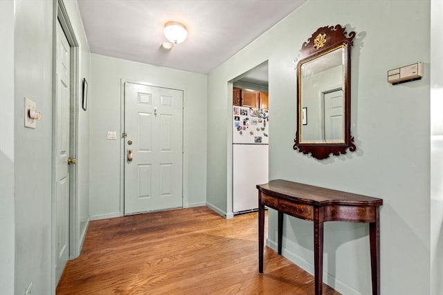 foyer with light wood-type flooring and baseboards