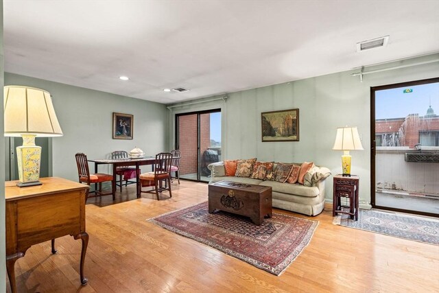 living room featuring recessed lighting, visible vents, and light wood-style floors