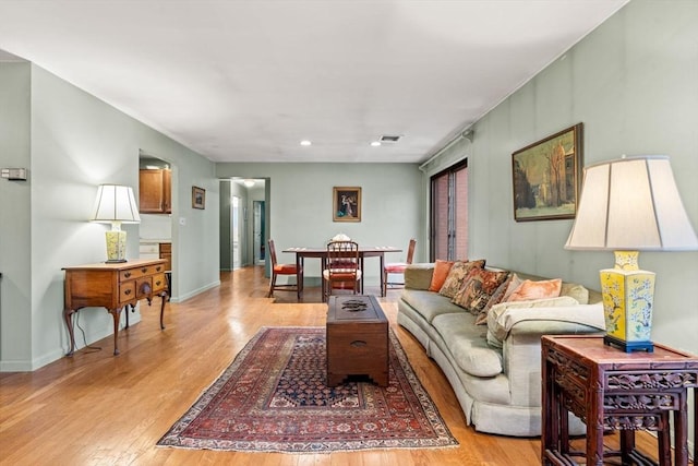 living room featuring recessed lighting, visible vents, light wood-type flooring, and baseboards