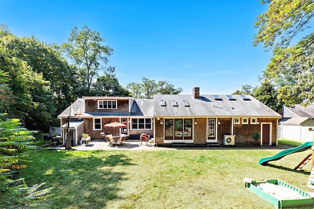 back of property featuring a playground, a lawn, and a patio area