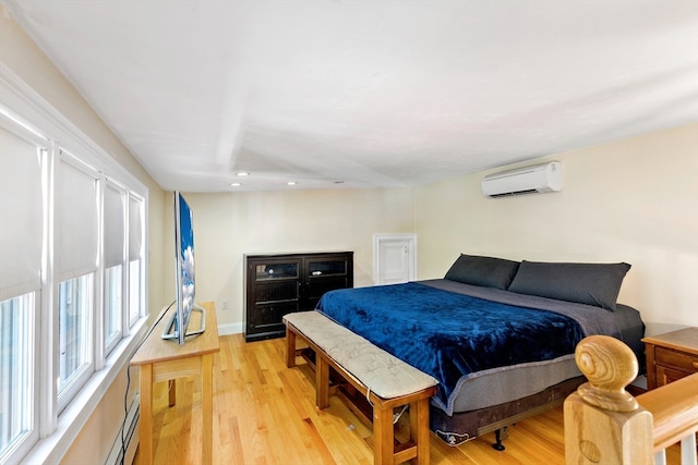 bedroom with light hardwood / wood-style floors and a wall mounted AC