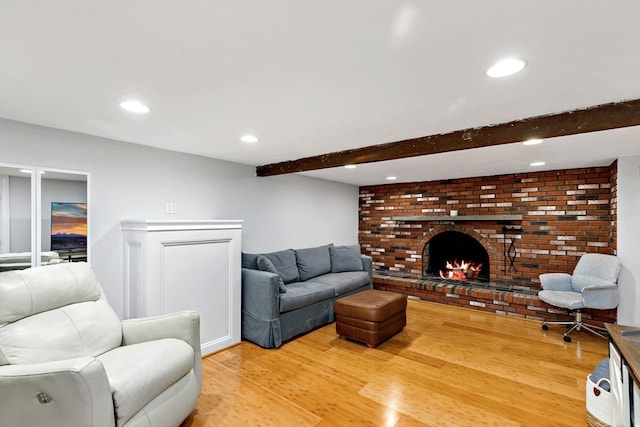 living room with wood-type flooring, a fireplace, and beamed ceiling