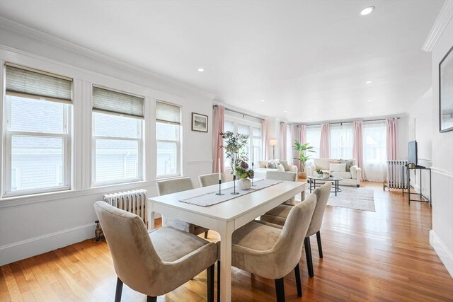 dining space with ornamental molding, light wood-type flooring, radiator heating unit, baseboards, and recessed lighting