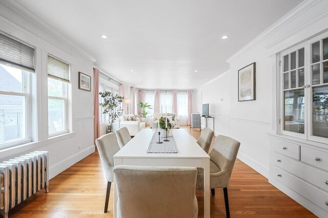 dining space featuring radiator heating unit, ornamental molding, healthy amount of natural light, light wood-style floors, and recessed lighting