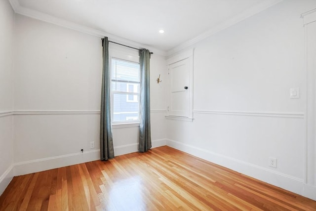 empty room with light wood finished floors, baseboards, ornamental molding, and recessed lighting