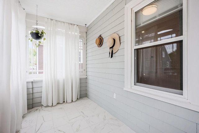 spare room featuring marble look tile flooring and wood walls
