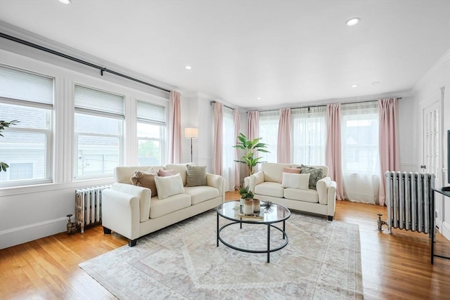 living area featuring ornamental molding, plenty of natural light, radiator, wood finished floors, and recessed lighting