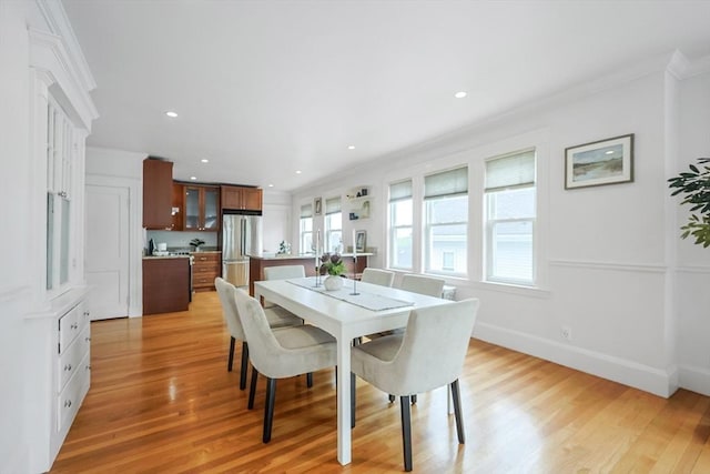 dining area with ornamental molding, light wood-style floors, baseboards, and recessed lighting