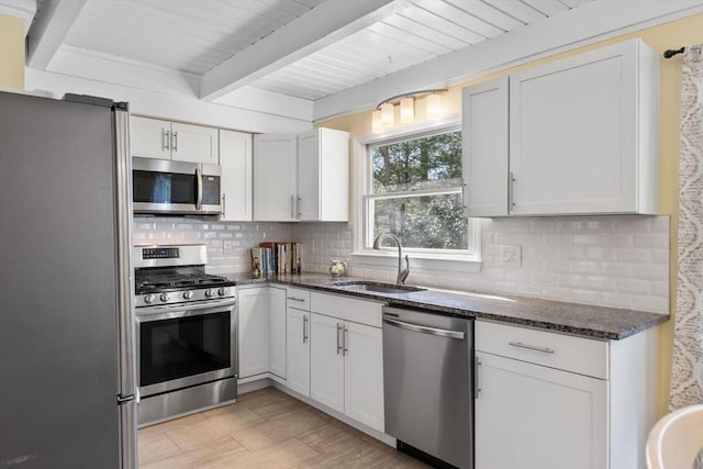 11 White Oak Trl, Barnstable, MA 02632 - kitchen featuring appliances with stainless steel finishes, a sink, beamed ceiling, dark stone counters, and decorative backsplash