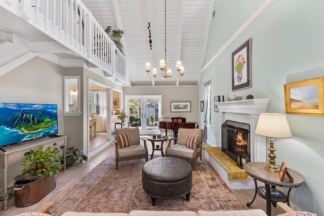 11 White Oak Trl, Barnstable, MA 02632 - living room with high vaulted ceiling, wood finished floors, a glass covered fireplace, a chandelier, and french doors
