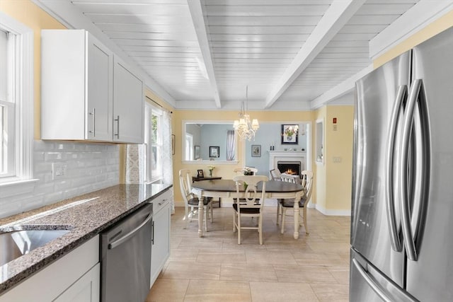 11 White Oak Trl, Barnstable, MA 02632 - kitchen with appliances with stainless steel finishes, tasteful backsplash, beam ceiling, dark stone countertops, and white cabinetry