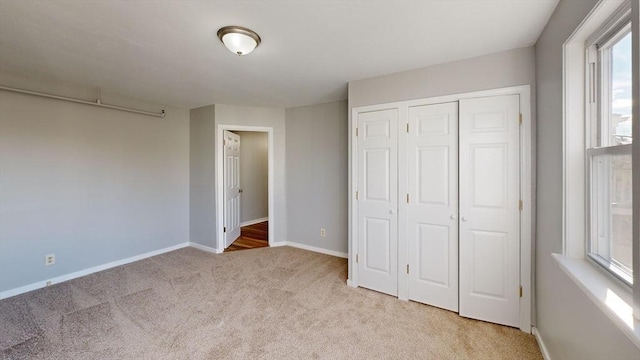 unfurnished bedroom with a closet and light colored carpet