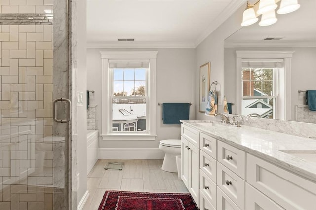 full bath with double vanity, a stall shower, toilet, crown molding, and a sink