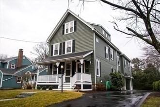 view of front of house featuring aphalt driveway, a front yard, and covered porch